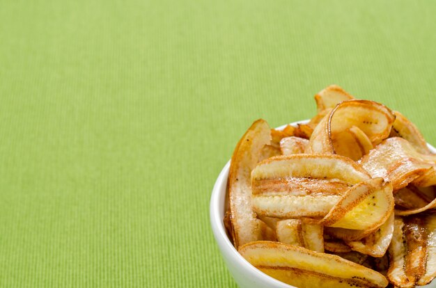 Foto chips de banana doce na toalha de mesa verde