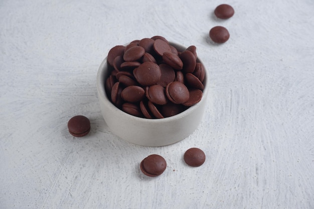 chips de chocolate ou pedaços de chocolate em uma tigela branca com textura de fundo branco isolado