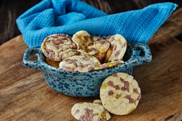 Chips de hojaldre con garbanzos, guisantes y frijoles en un plato con una toalla sobre fondo de madera