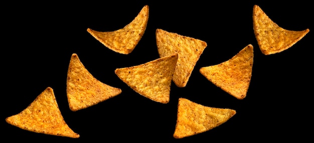 Chips de maíz picante cayendo nachos mexicanos calientes aislados en un fondo negro