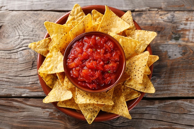 Chips mexicanos de nachos e salsa em uma tigela de madeira