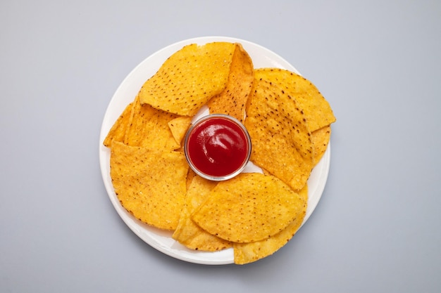Unos chips de nachos mexicanos en plato pequeño con salsa