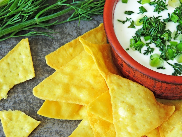 Chips de nachos con salsa de crema agria y verduras.