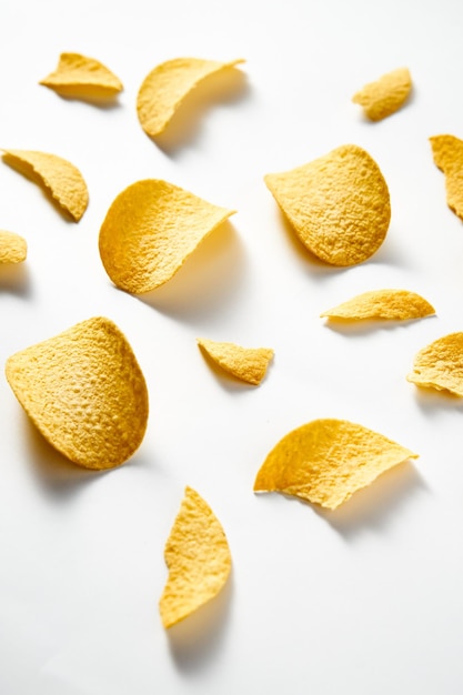 Foto chips de patata dorados y crujientes sobre un fondo blanco foto de comida minimalista