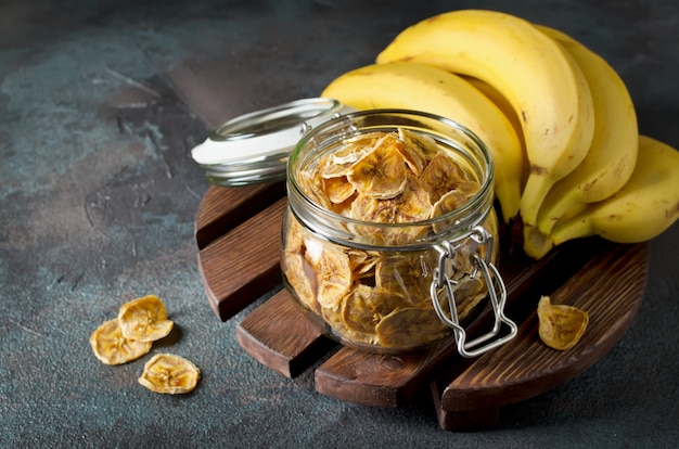 Foto chips de plátano caseros en un frasco de vidrio