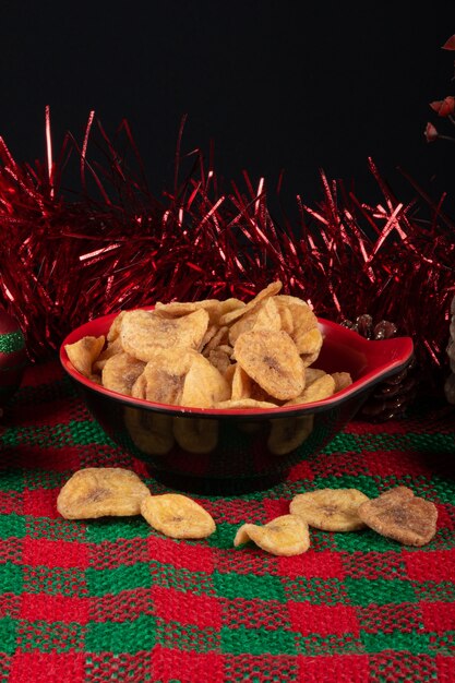 Chips de plátano en un recipiente sobre un fondo de Navidad