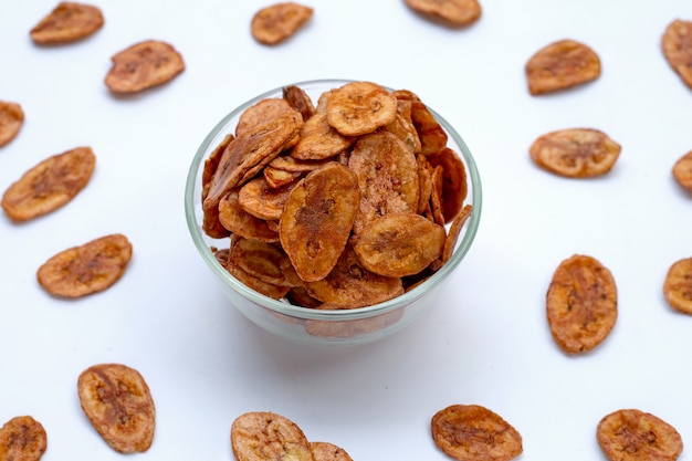 Chips de plátano en superficie blanca.