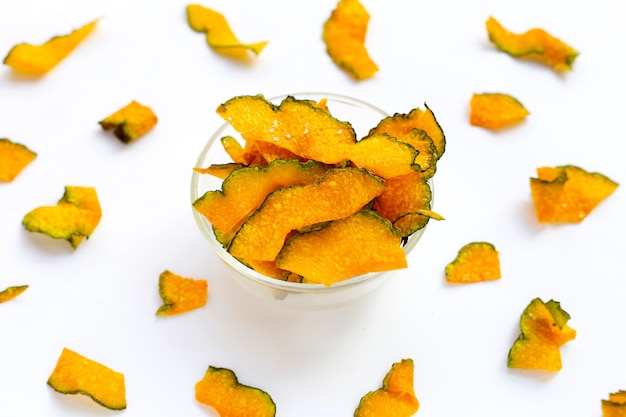 Chips de rebanada de calabaza verde sobre fondo blanco.