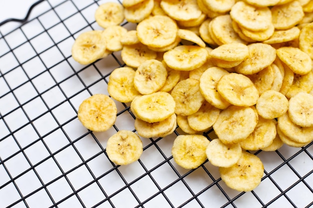 Foto chips de rebanada de plátano sobre fondo blanco.