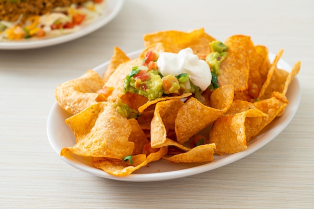 Foto chips de tortilla de nachos mexicanos con jalapeño, guacamole, salsa de tomate y salsa