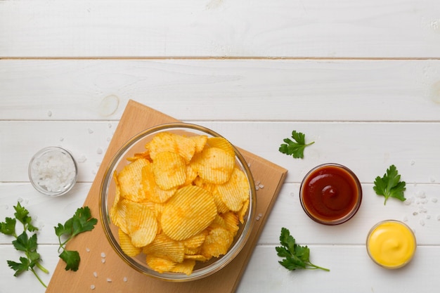 Chips de vista superior con salsa en un tazón sobre fondo de color vista superior con espacio de copia