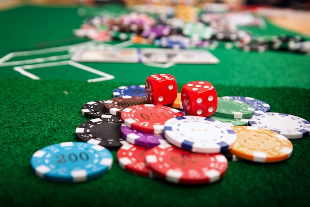 Chips von farbigen Casinos, die auf dem grünen Tisch platziert sind, sind Münzen, die verwendet werden, um in Casin zu wetten