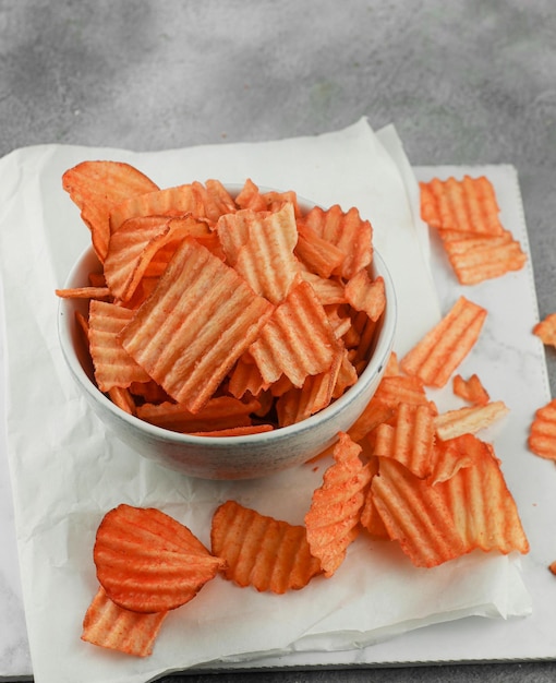 Chips de yuca con sabor a queso servidos en un tazón con un tema blanco