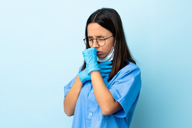 Chirurg Frau über isolierte blaue Wand viel hustend