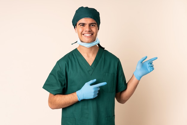 Chirurg Mann in blauer Uniform über Wand zeigt Finger zur Seite