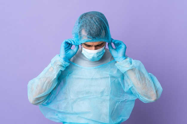 Foto chirurg mann mit bart mit blauer uniform auf isoliertem purpur