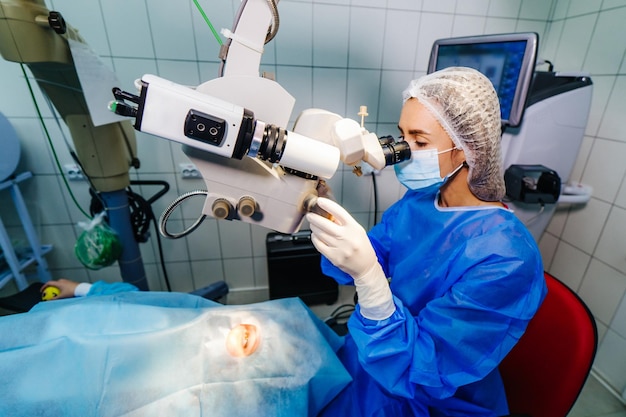 Chirurg mit Betriebssystem der Laser-Sehkorrektur im Operationssaal Ophthalmologischer Operationsprozess