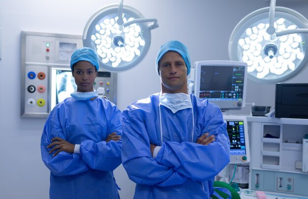 Foto chirurgen stehen zusammen mit gekreuzten armen im operationssaal