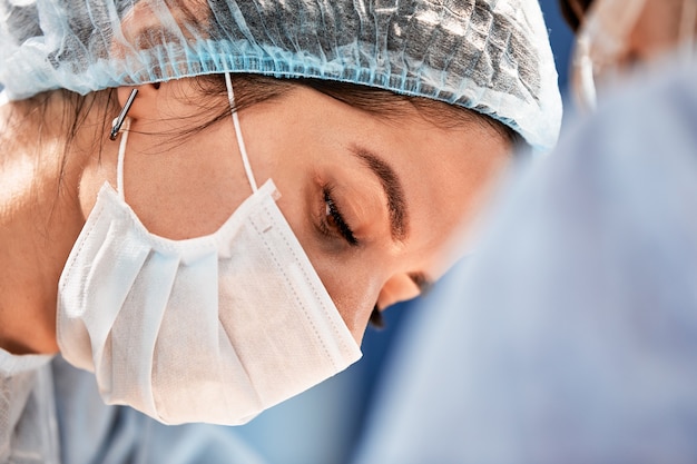 Chirurgin im Operationssaal Nahaufnahme, Ärztin Gesicht während der Operation.