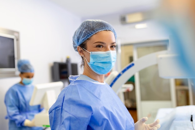 Chirurgin mit chirurgischer Maske im Operationssaal Junge Ärztin in chirurgischer Uniform im Operationssaal des Krankenhauses