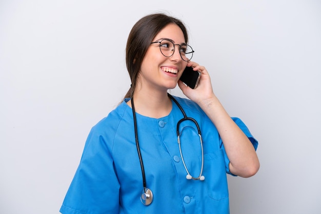 Chirurgische Ärztin, die Werkzeuge isoliert auf weißem Hintergrund hält und ein Gespräch mit dem Mobiltelefon führt