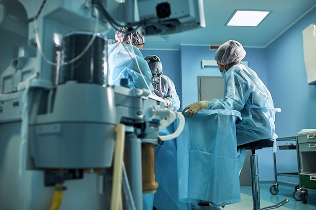 Chirurgischer Operationssaal im Krankenhaus Lebensrettende Beatmung der Lunge mit Sauerstoff Vor dem Hintergrund eines Teams von Chirurgen während der Operation
