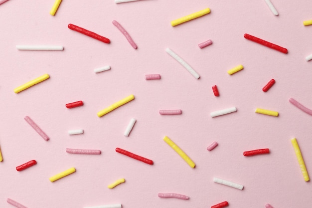 Chispitas de colores sobre un fondo rosa, vista superior con espacio de copia. Pascua vacaciones. Celebración de cumpleaños.