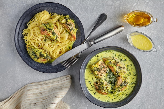 Foto chkemeruli em um prato escuro com molho de talheres azeite e pano de cozinha