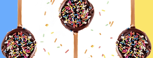 Foto chocolate alfajor en palito de helado oblea rellena de chocolate y chispitas