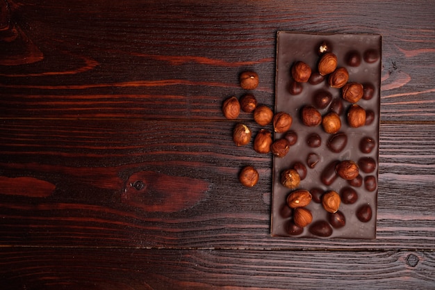 Chocolate amargo com avelãs na mesa de madeira