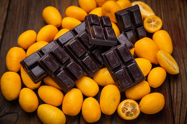 Chocolate amargo e kumquat em uma mesa de madeira