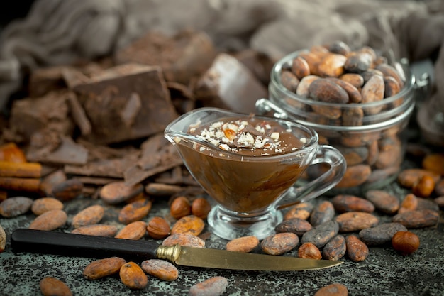 Chocolate amargo em uma composição com grãos de cacau e nozes, sobre um fundo antigo.