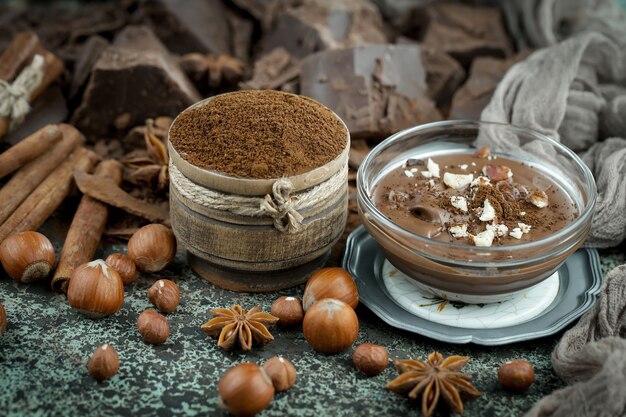 Chocolate amargo em uma composição com grãos de cacau e nozes, sobre um fundo antigo.