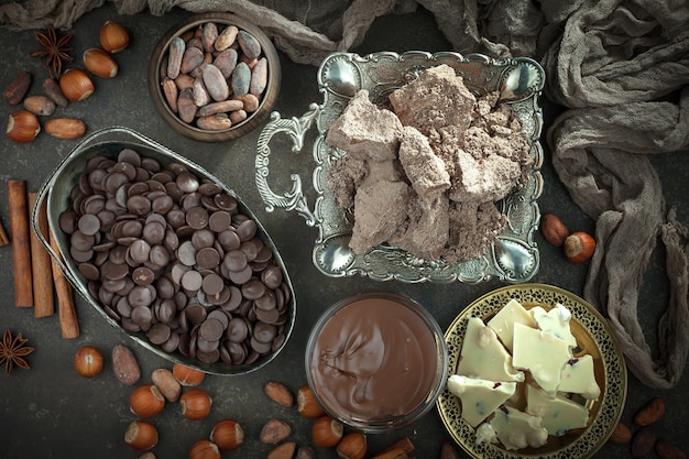 Chocolate amargo em uma composição com grãos de cacau e nozes, sobre um fundo antigo.