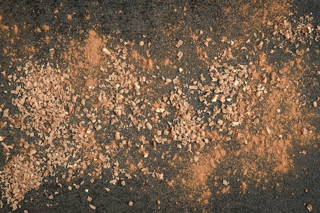 Chocolate ao leite em barra de chocolate e cacau na superfície preta