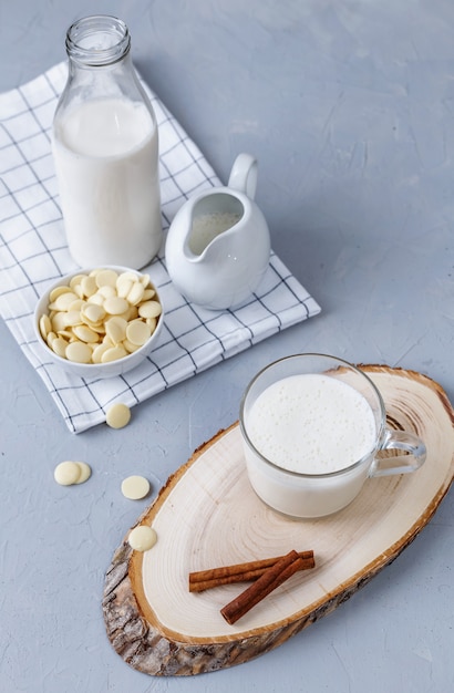 Chocolate blanco caliente y canela sobre un soporte de madera sobre una superficie gris. Concepto de desayuno saludable Keto bebe.