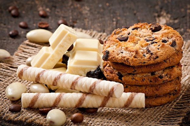 Chocolate branco, amêndoas e biscoitos numa superfície de madeira