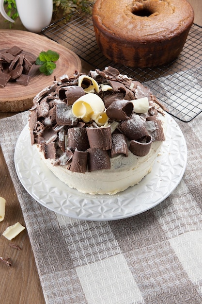 Chocolate branco e bolo de chocolate escuro dois amores na mesa de madeira Aniversário e bolo de casamento