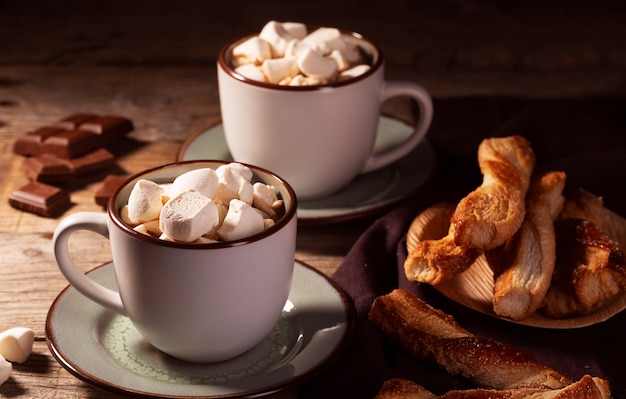 Foto chocolate caliente con canela y malvavisco sobre fondo de madera