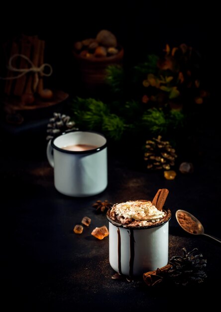 Chocolate caliente con crema batida y cacao en polvo en tazas de metal Tiempo de invierno y otoño Bebida caliente de Navidad Espacio de copia