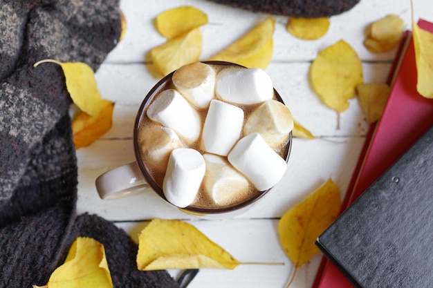 Chocolate caliente con dulces de malvavisco, hojas de otoño