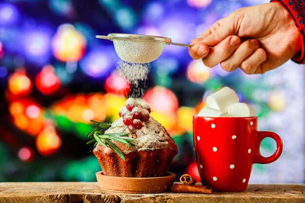 Chocolate caliente en el fondo de un árbol de Navidad con un cupcake de Navidad Dulces para el nuevo año