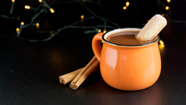 Chocolate caliente de invierno en una taza de naranja.