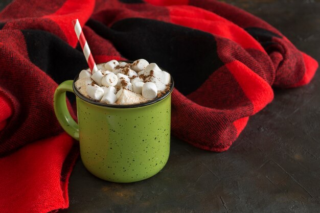 Chocolate caliente con malvavisco en una taza verde