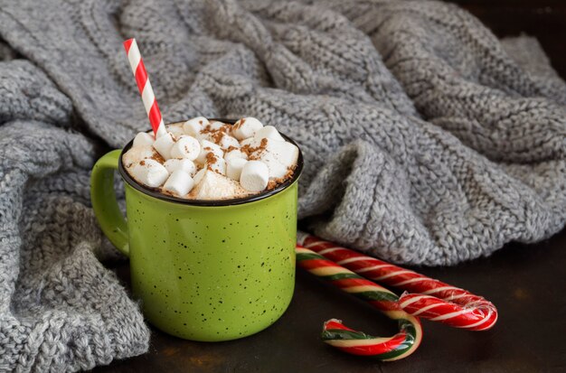 Chocolate caliente con malvavisco en una taza verde