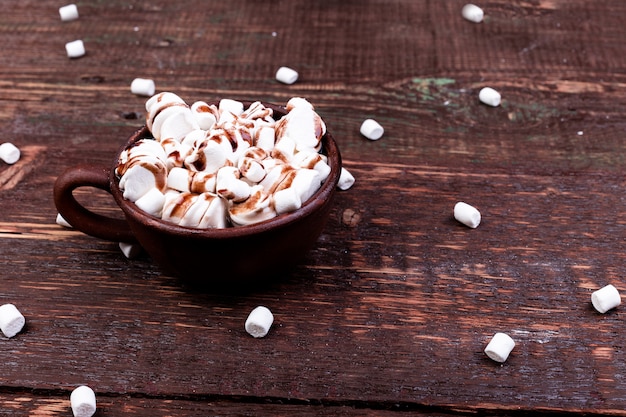 Chocolate caliente con malvaviscos en una taza marrón