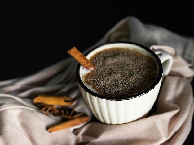 Chocolate caliente en una taza blanca sobre fondo de maderaleche de cacao con especias chinamon bebida dulce bocadillo de invierno en la mañana o bebida de temporada de navidad para celebrar el concepto de feliz año nuevo 2023