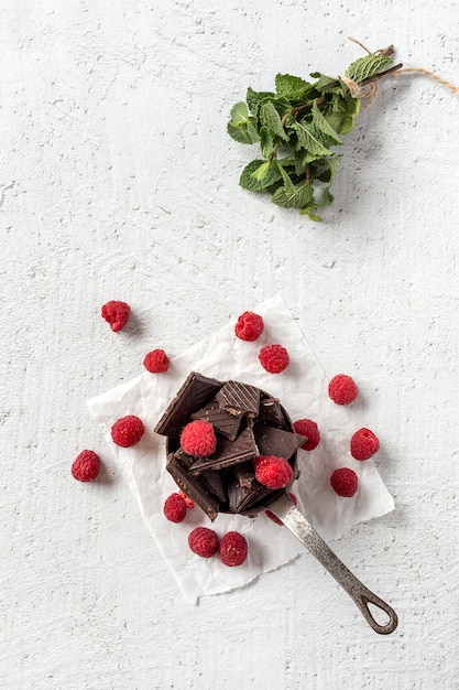 Foto chocolate con chiles rojos, menta y frambuesas.