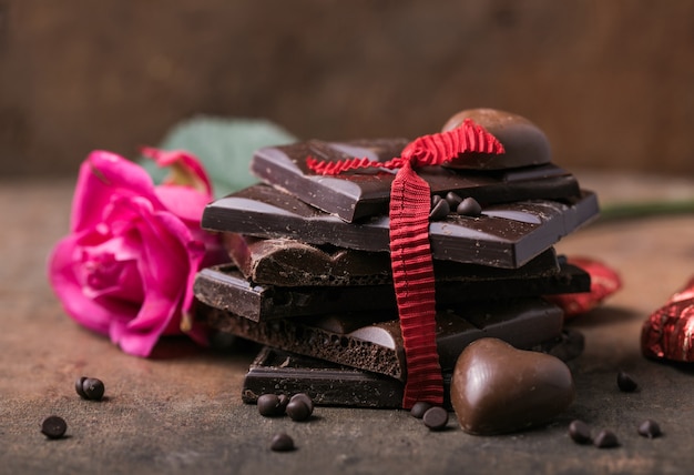 Chocolate con cinta, rosa y corazón en el amor de San Valentín.