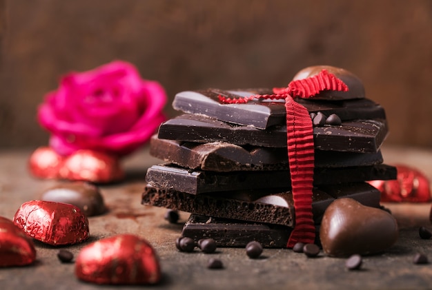 Chocolate con cinta, rosa y corazón en el amor de San Valentín.